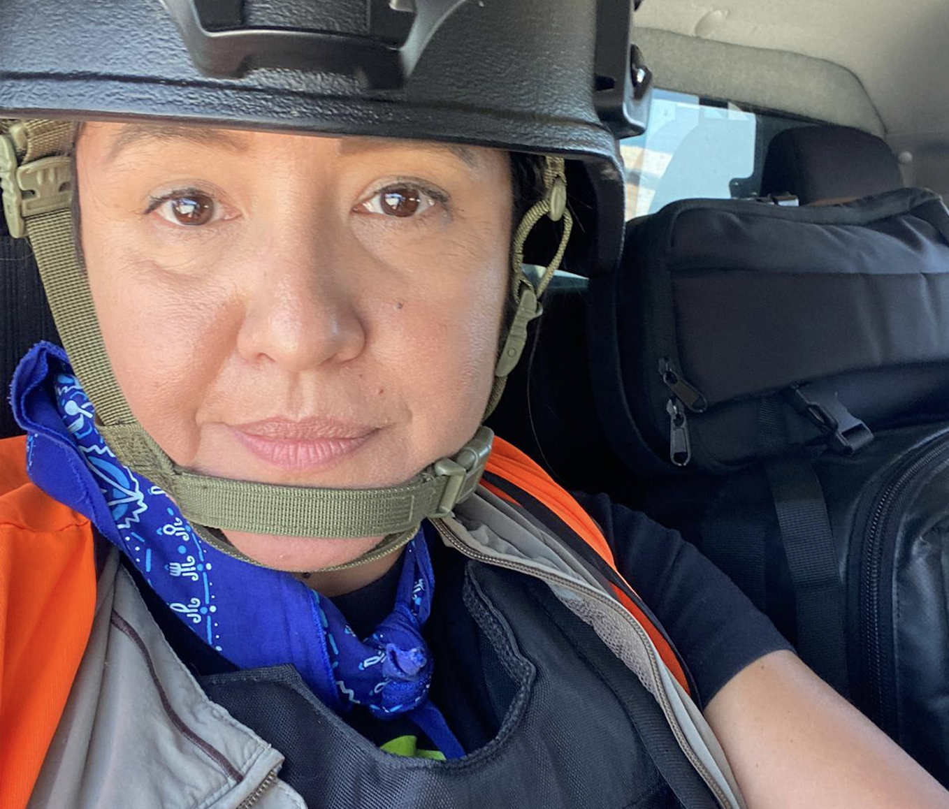 a woman in a black helmet in the back of a car